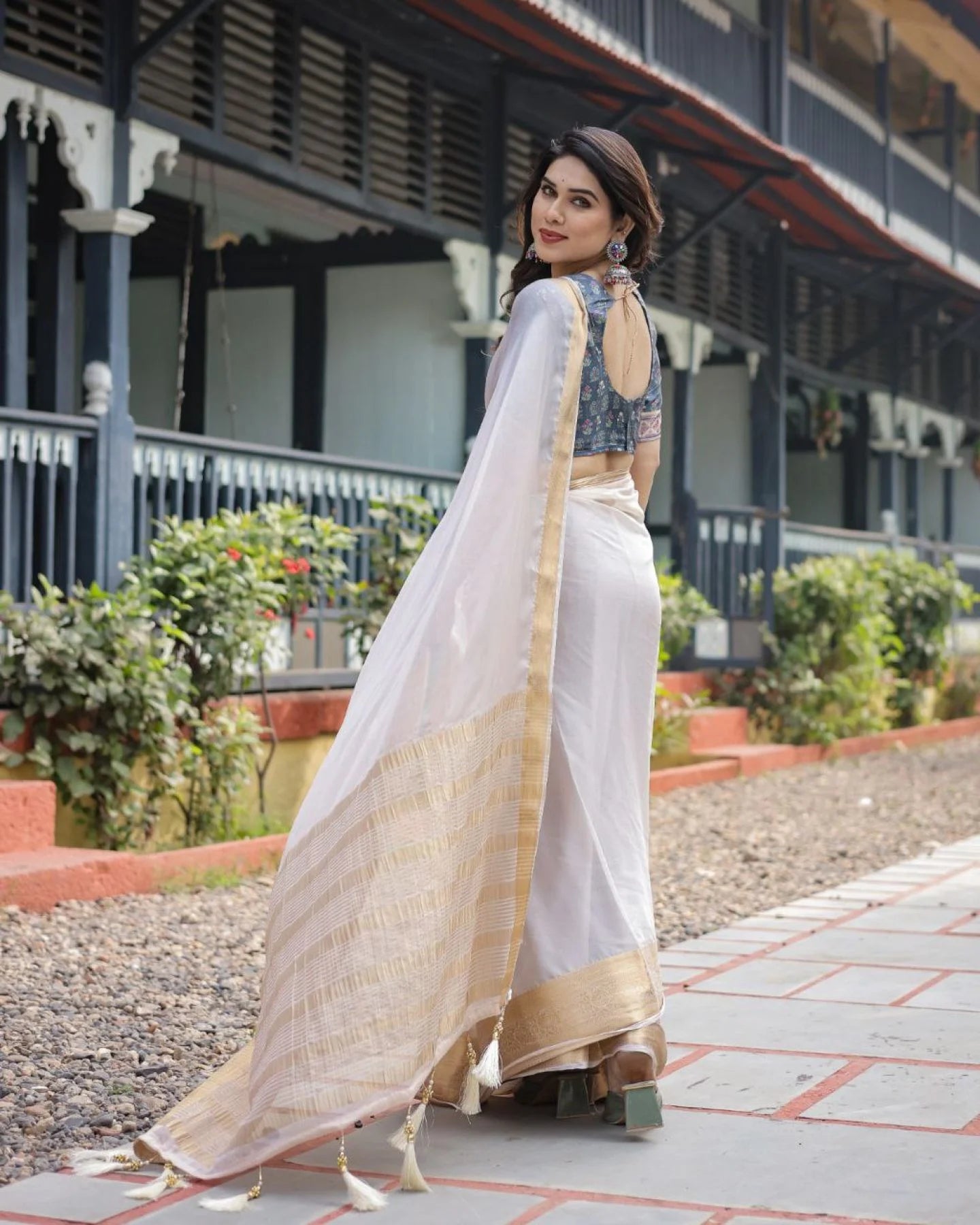 Classic cream white chiffon saree with a contrast blouse piece and a rich golden zari border