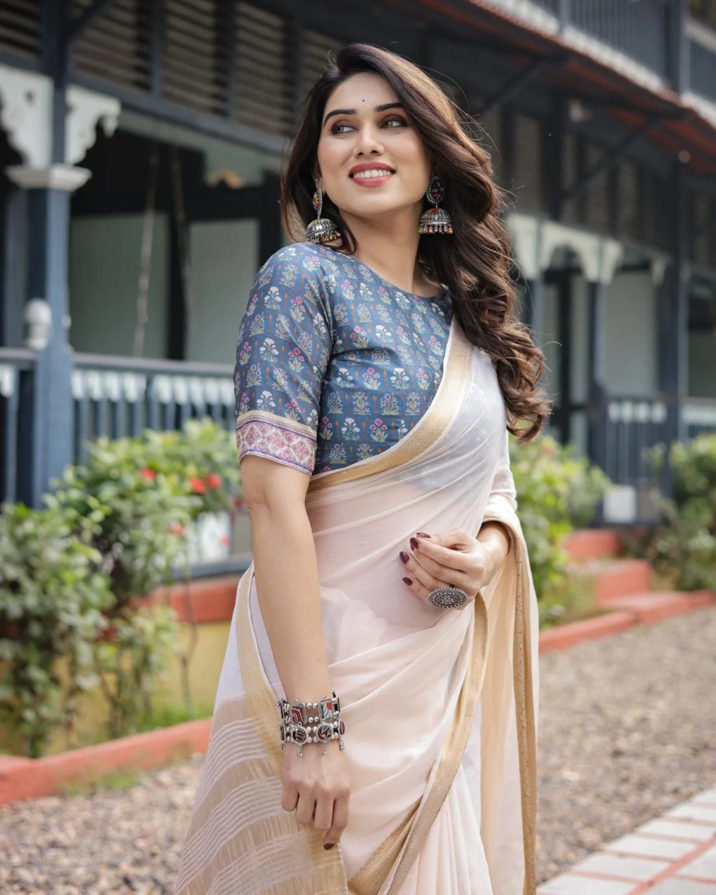 Classic cream white chiffon saree with a contrast blouse piece and a rich golden zari border